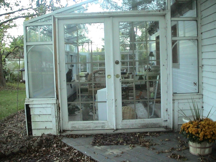 an old white house that has two big windows