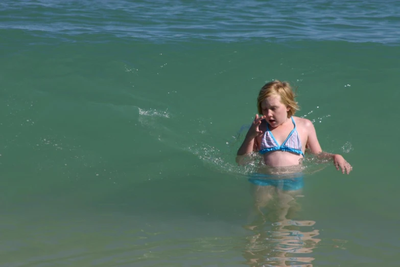 a child on her cell phone is in the water