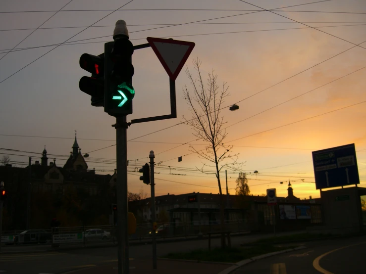 a traffic light on an intersection with power lines and buildings in the background