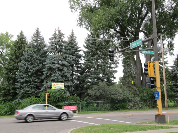 two green street signs in the intersection of a street and cars