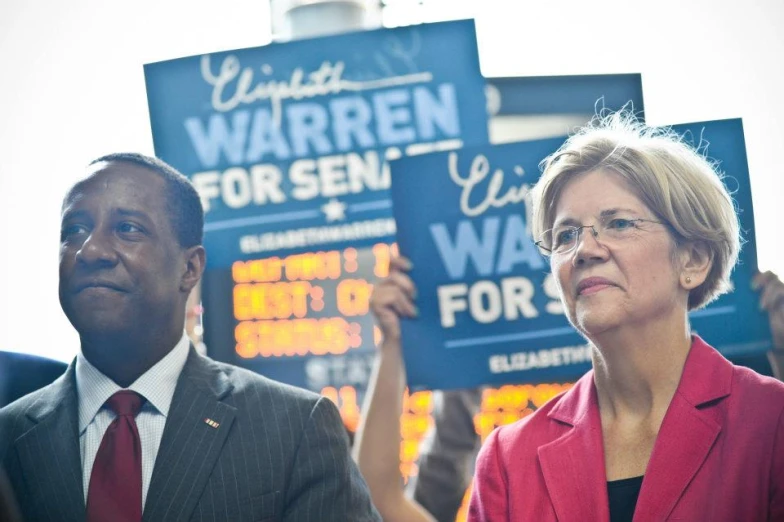 the two women hold up their signs and sing