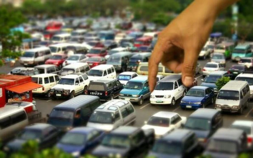 there is a finger pointed at cars in a traffic jam