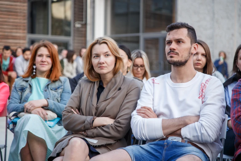 a group of people sitting on chairs at an outdoor event