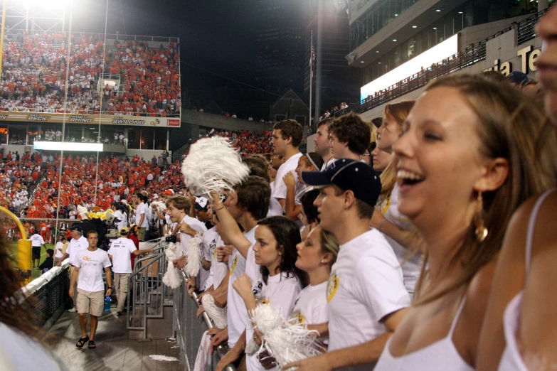 a woman standing on a chair at a football game