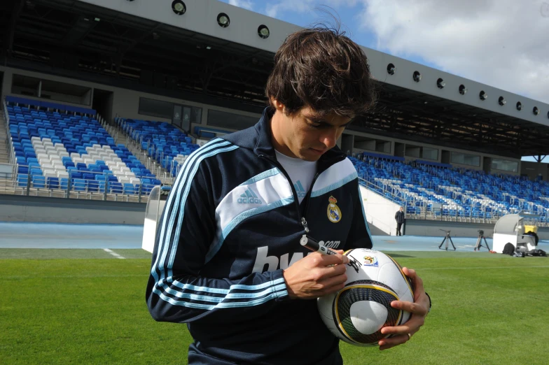 a man holding a ball and soccer ball on the field