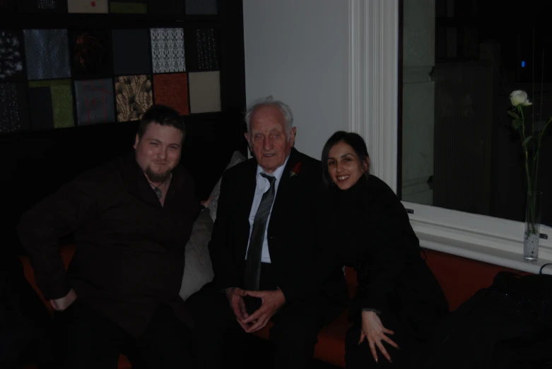 three people pose for a po in front of a window