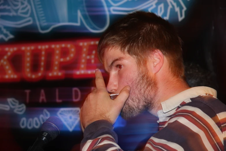 a man with a beard stands in front of a microphone