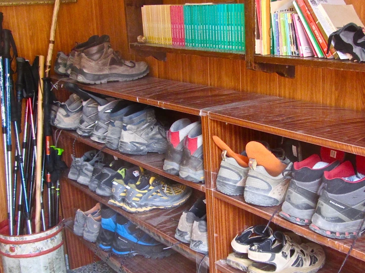 the inside of a bookshelf has various types of sports shoes