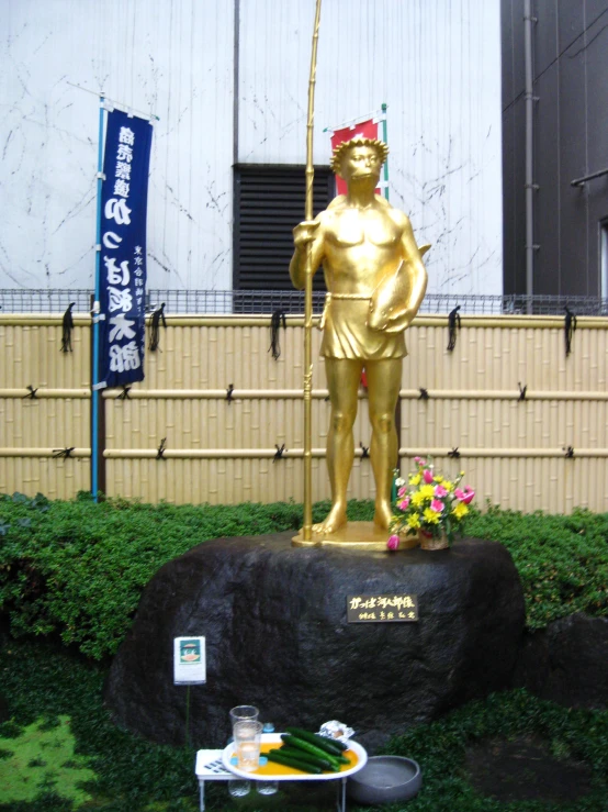 a golden statue sitting on top of a green field