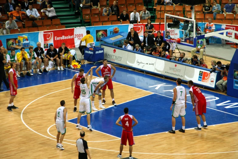 a group of people that are standing on a basketball court