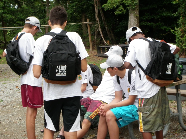 a group of s are gathered around a bench