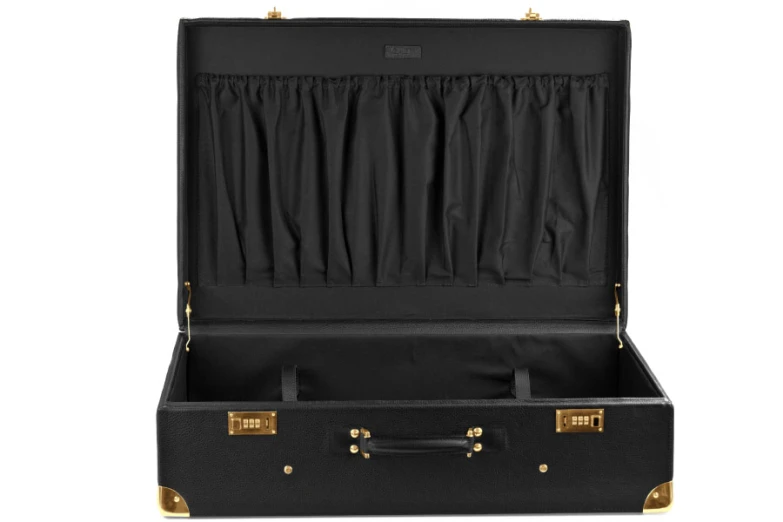 a large black suit case with gold trim and handles