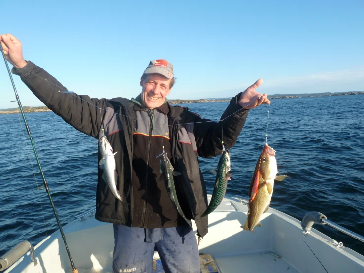 a man holding two fish on a boat