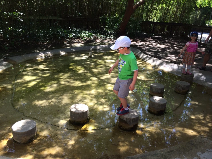 two children playing in the water at a park