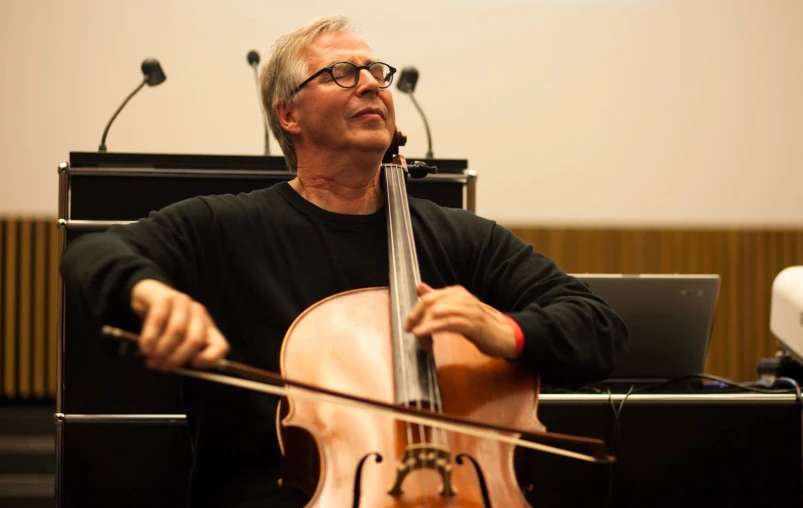 a male classical instrument player is holding the strings for a presentation