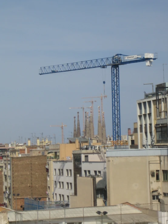 a crane is standing over buildings that are under construction