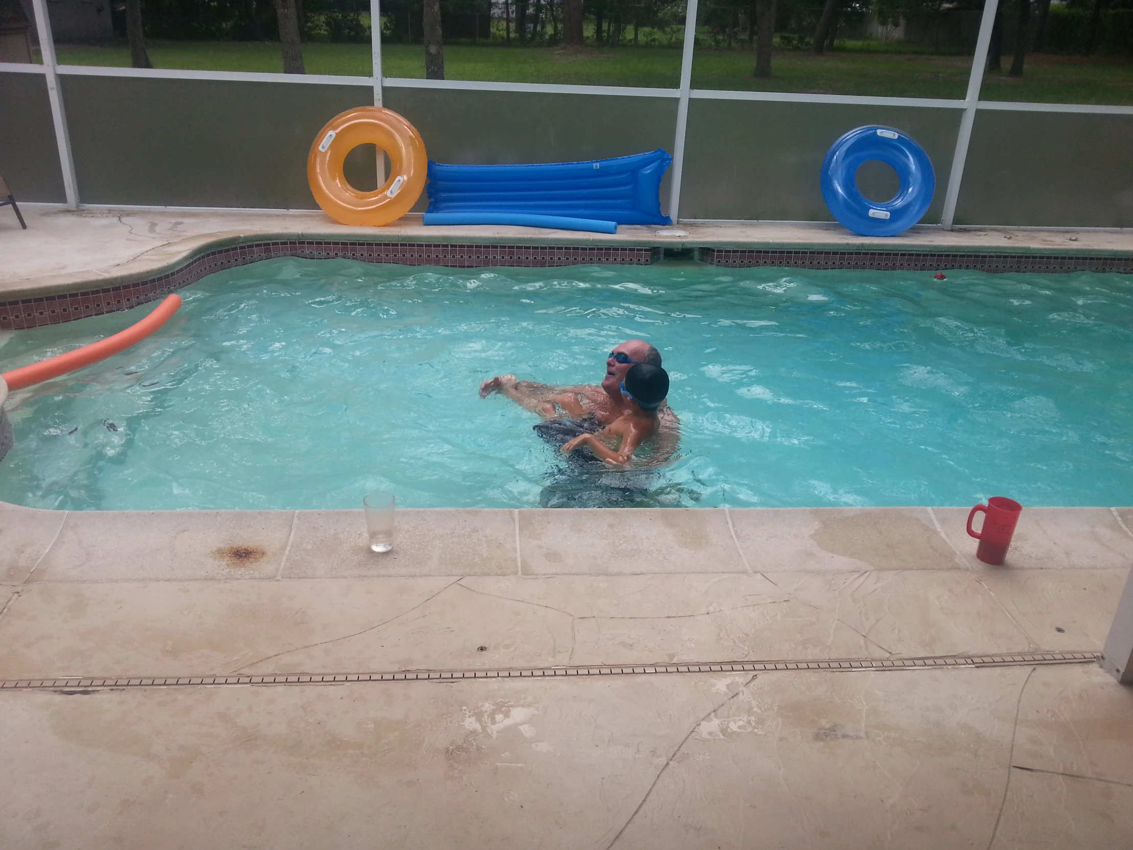 a man who is in the water next to a swimming pool