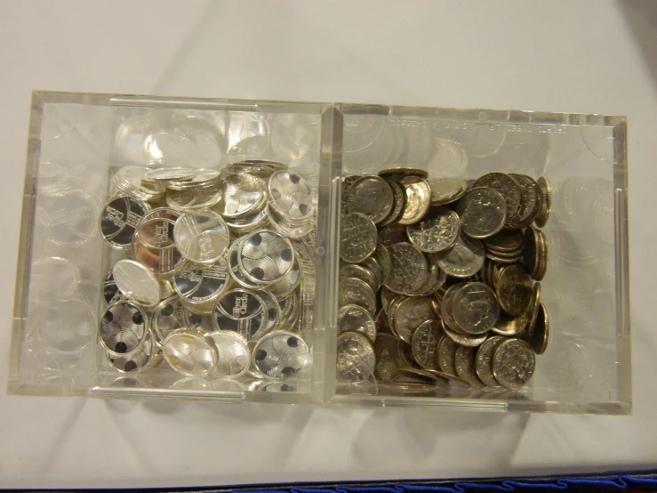 two boxes filled with money sitting on top of a white surface