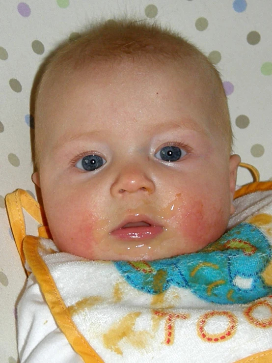 a small child with blue eyes sits in a crib