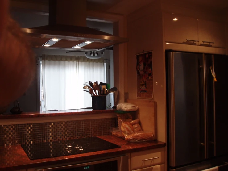 a very dimly lit kitchen has a granite counter top