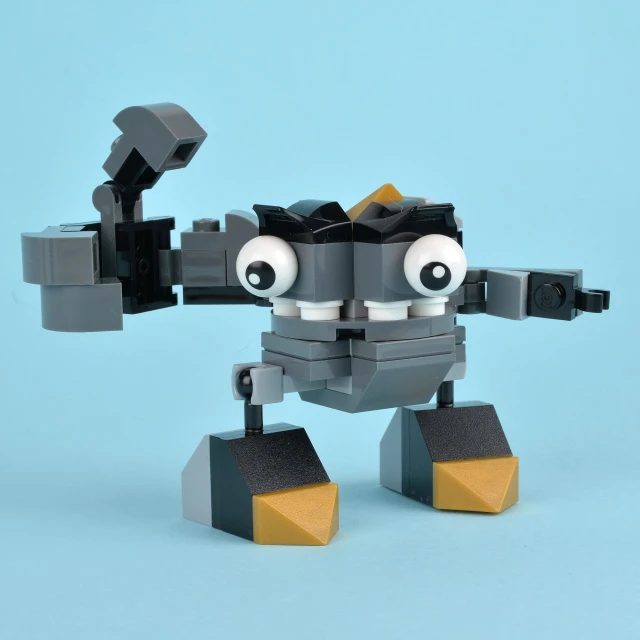 a grey lego robot with black arms and eyes