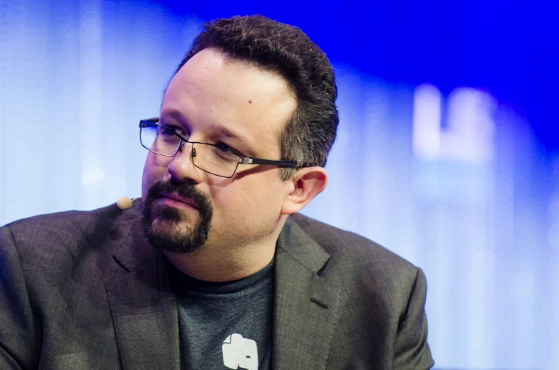 the man with glasses looks pensive on a blue background