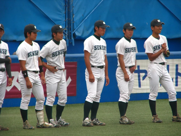 four baseball players standing in a line together