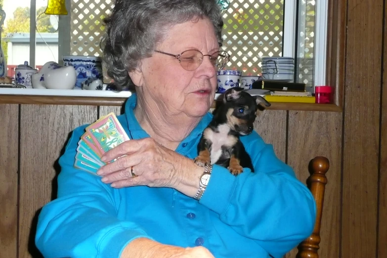 a woman holding a dog and two cards in her hand