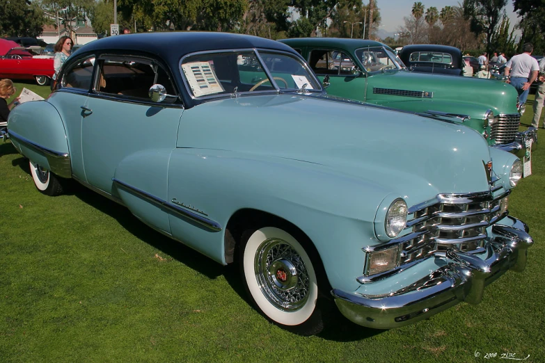 antique blue cars at a car show on the grass