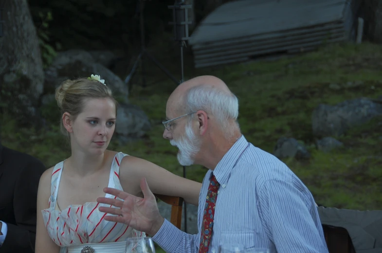 a woman in a white dress talking to a man