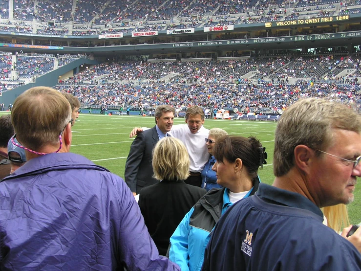 several people standing around on a field near some football