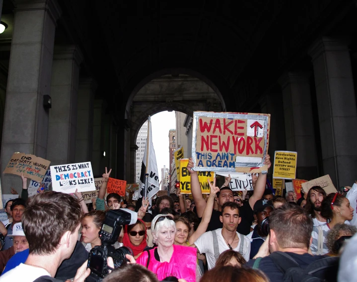 people holding up signs and posing in front of a crowd