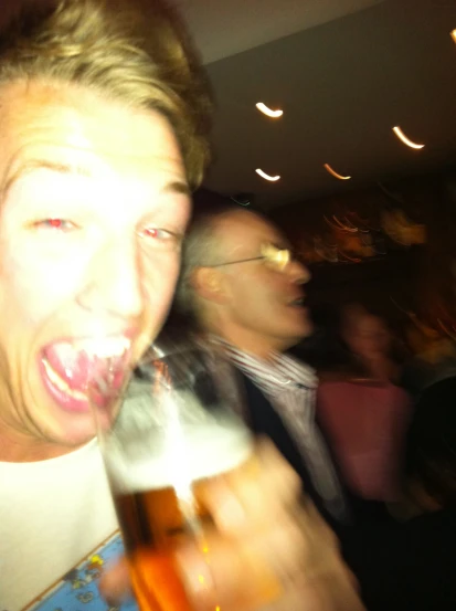 a man holding a beer up to his mouth