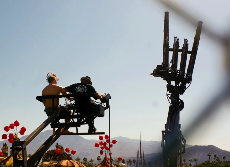 two people are riding a roller coaster with flowers behind them