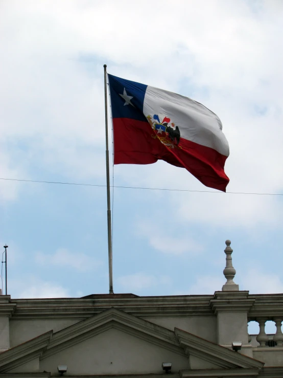 a flag flies from top of a building in the sky