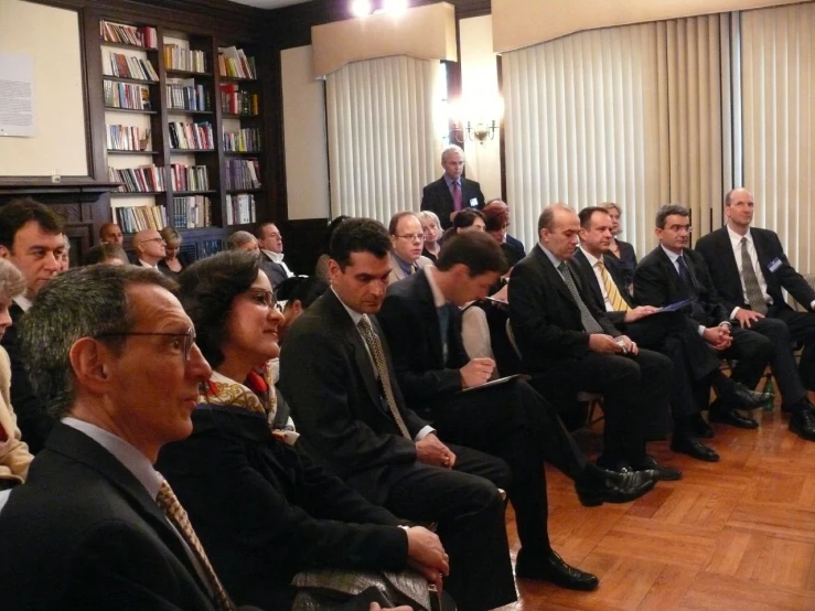 a group of business people are sitting in a room