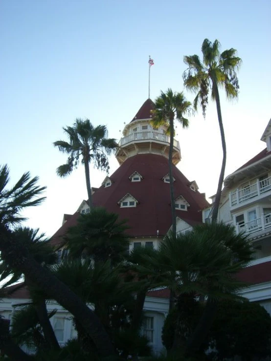 the top of a building with a tower surrounded by palm trees