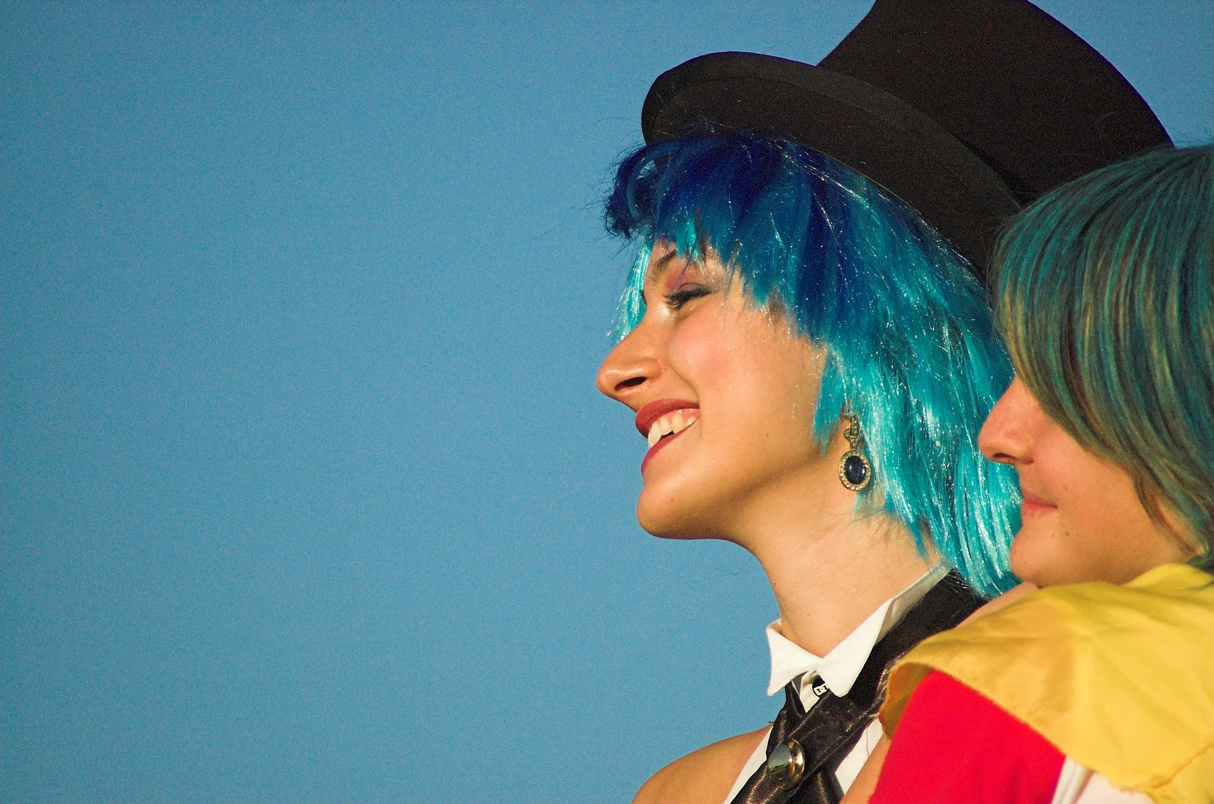 a close up of two people with blue hair and one wearing a black hat