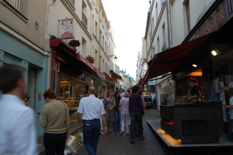 people walking on a city street and eating