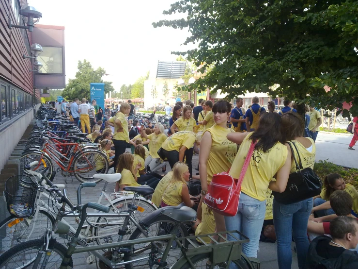 a group of people in yellow shirts standing next to bikes