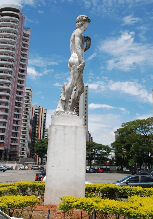 a statue of a man holding a snake in a city park