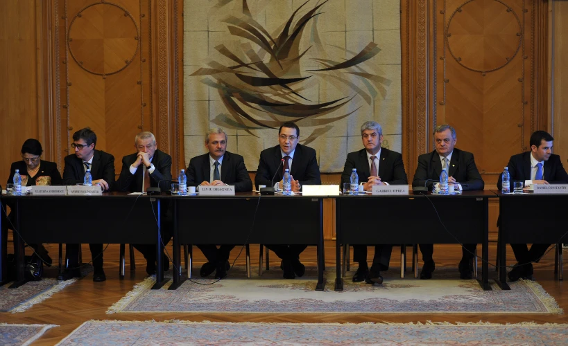 the men are sitting in front of the conference table