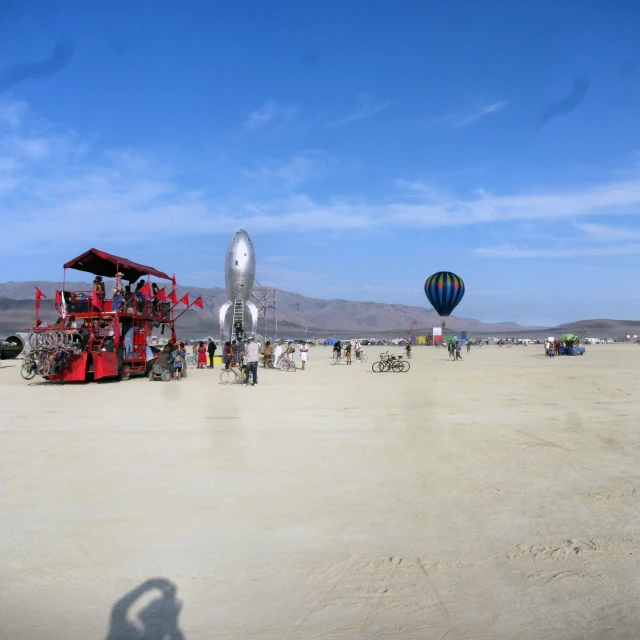 a beach with a large balloon and a small stage