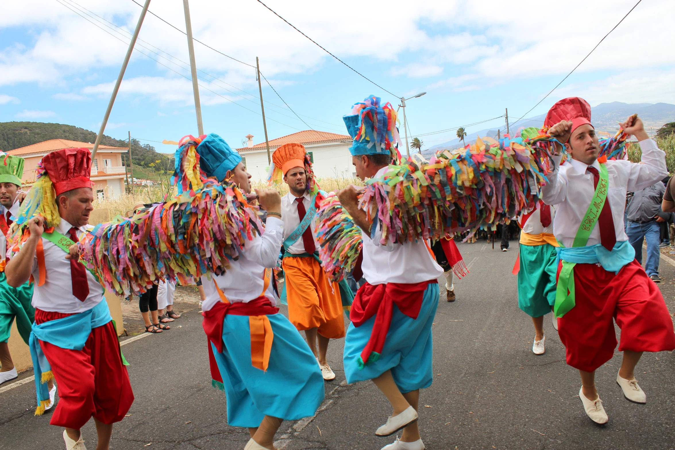 people in colorful clothes with big ties dance