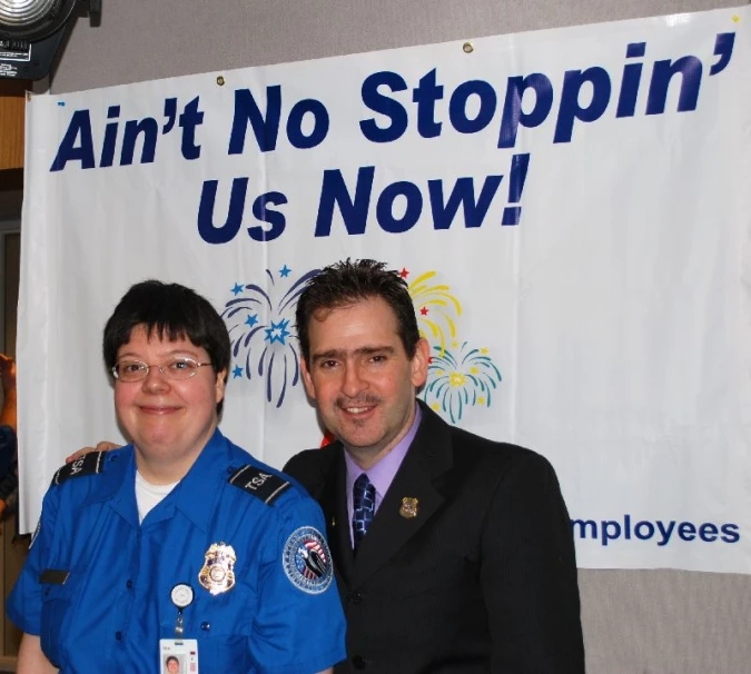 a couple of people standing in front of a sign