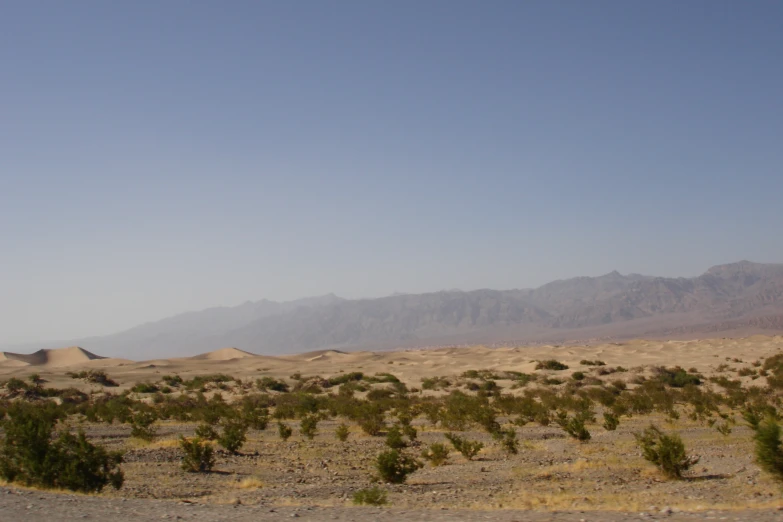 an arid valley with hills in the distance