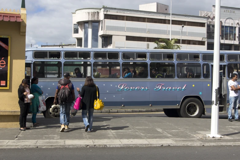 group of people boarding blue transit bus near city