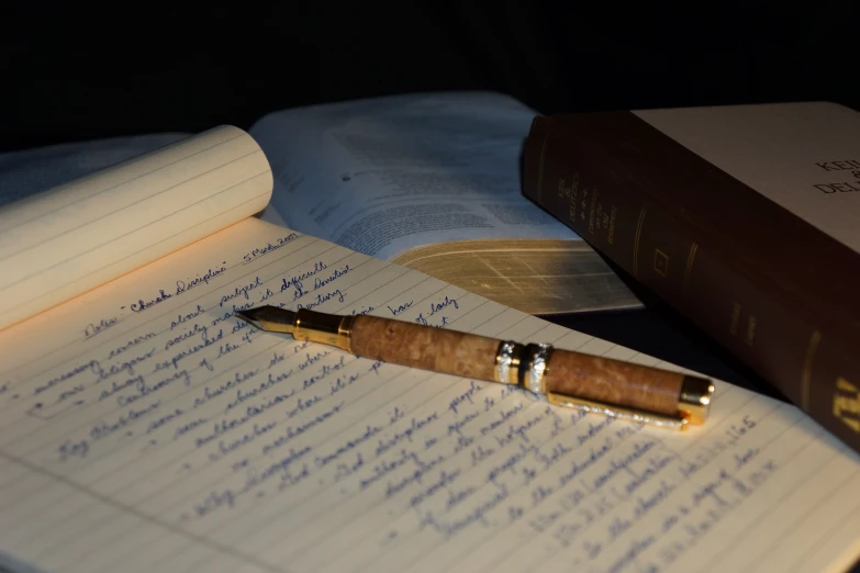 a pen resting on a notebook in the dark