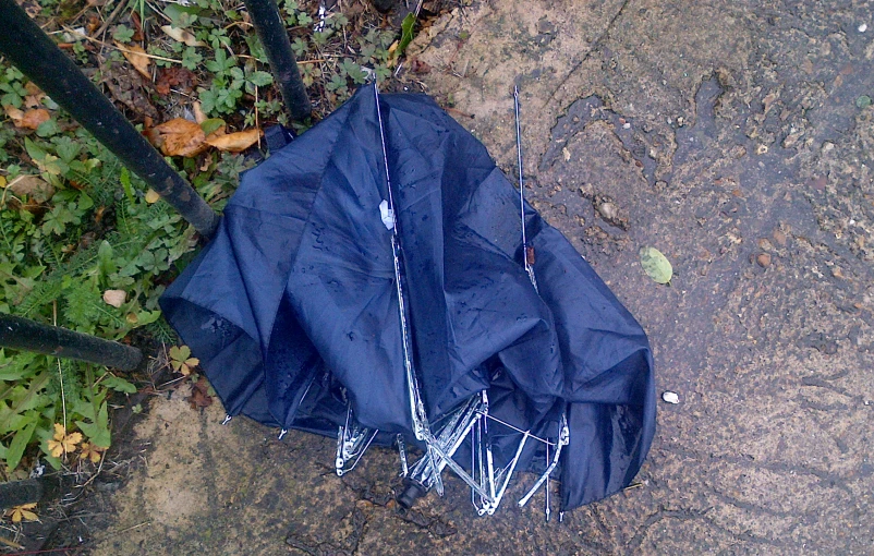 an umbrella is placed on the ground next to some sticks
