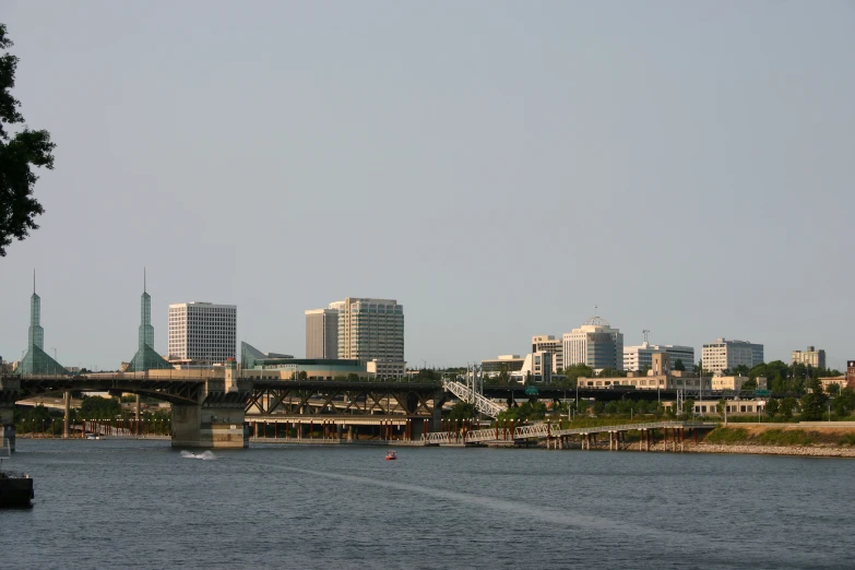 the large bridge crosses the river between two cityscapes